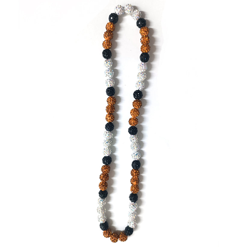 Necklace with black, orange, and white beads on a white background